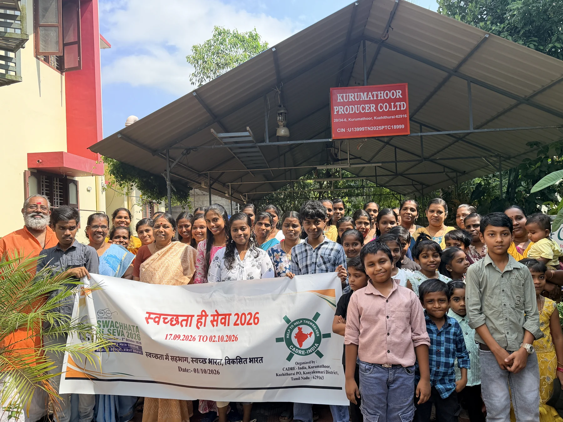 Staff and community members gathered with a Swachh Bharat rally banner